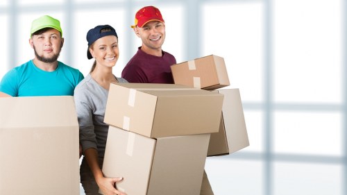 Removalists handling furniture carefully in a local home