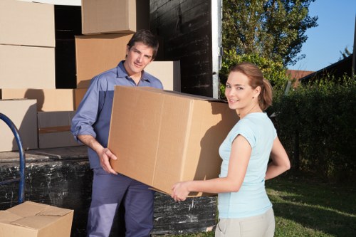 Commercial movers carrying office items through a narrow access point